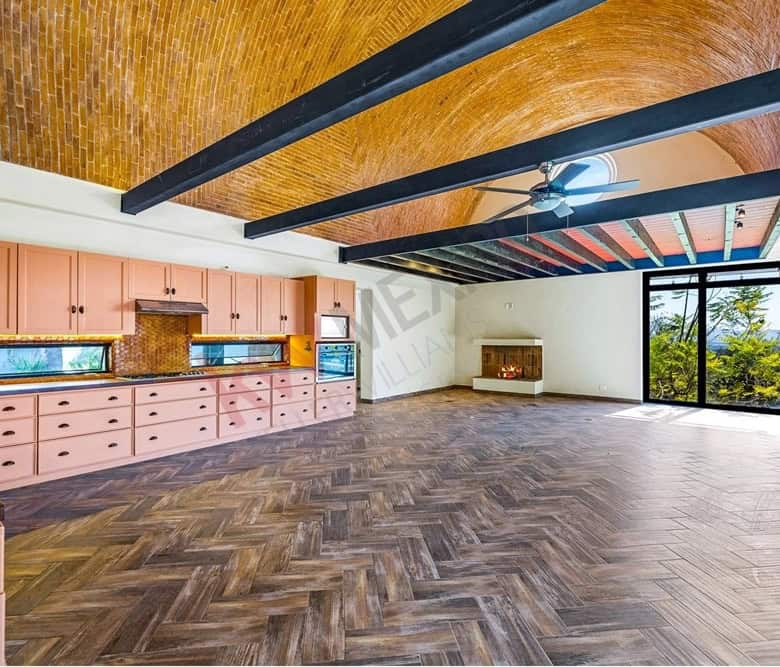 Spacious living area with high ceilings, large windows, and wooden beams, offering a bright and airy.