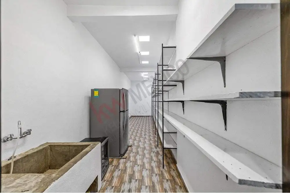 Modern kitchen with white shelves and wooden flooring for sale.