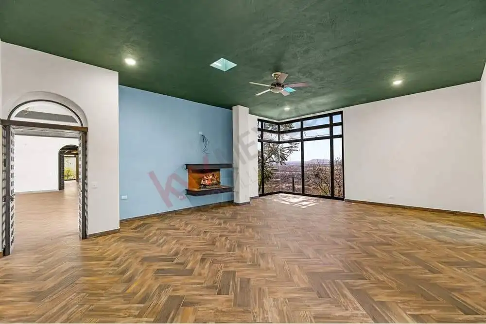 Bright living room featuring expansive windows, a cozy fireplace, and stylish wooden flooring. Perfe.