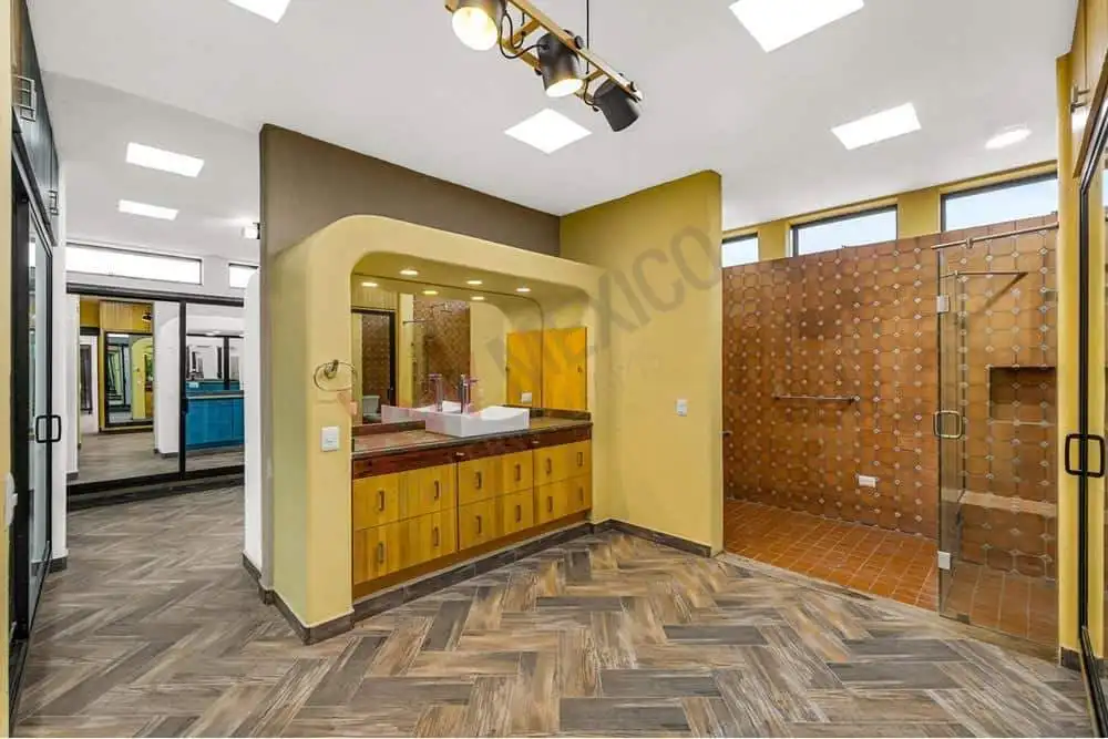 Modern bathroom with wooden vanity and glass shower enclosure.