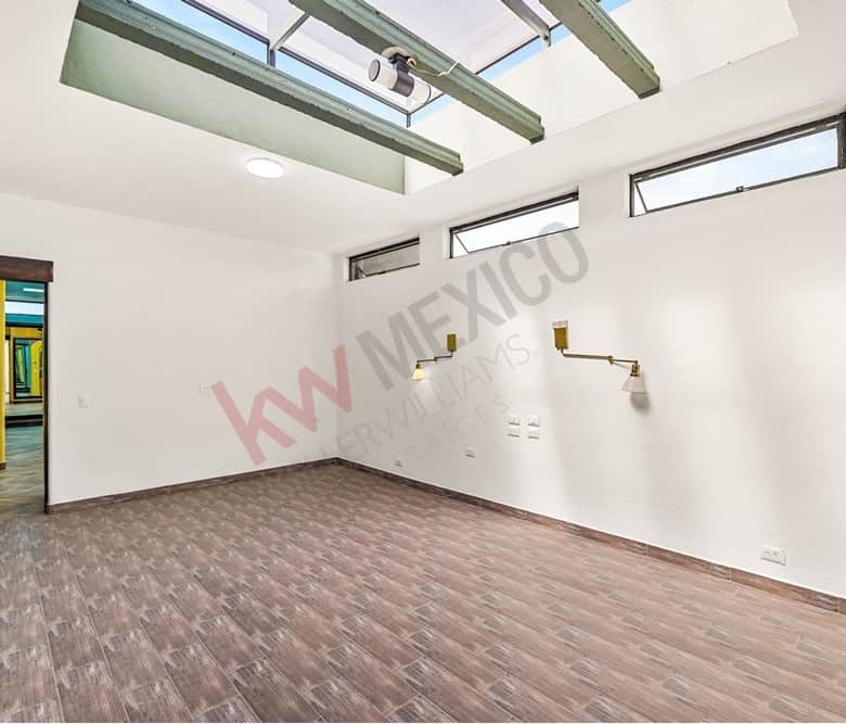 Interior office room with large windows and skylights for natural light.