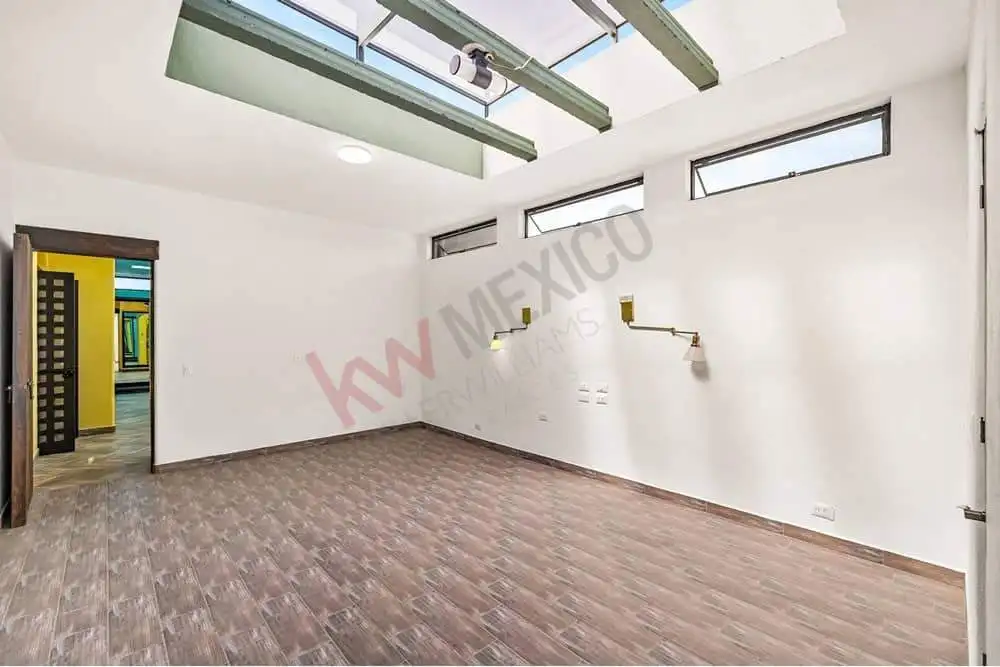 Interior office room with large windows and skylights for natural light.