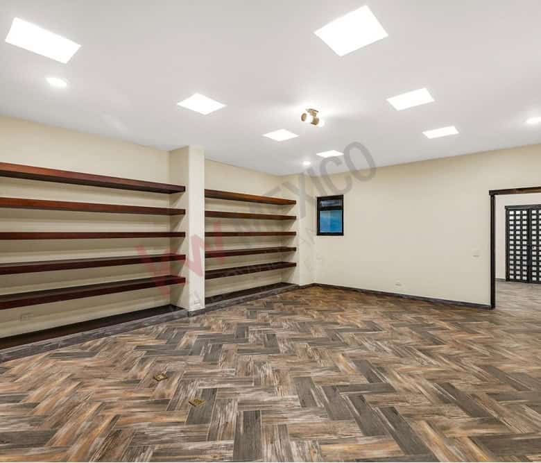 Empty retail store interior with wooden flooring and wall-mounted shelves for shop display.
