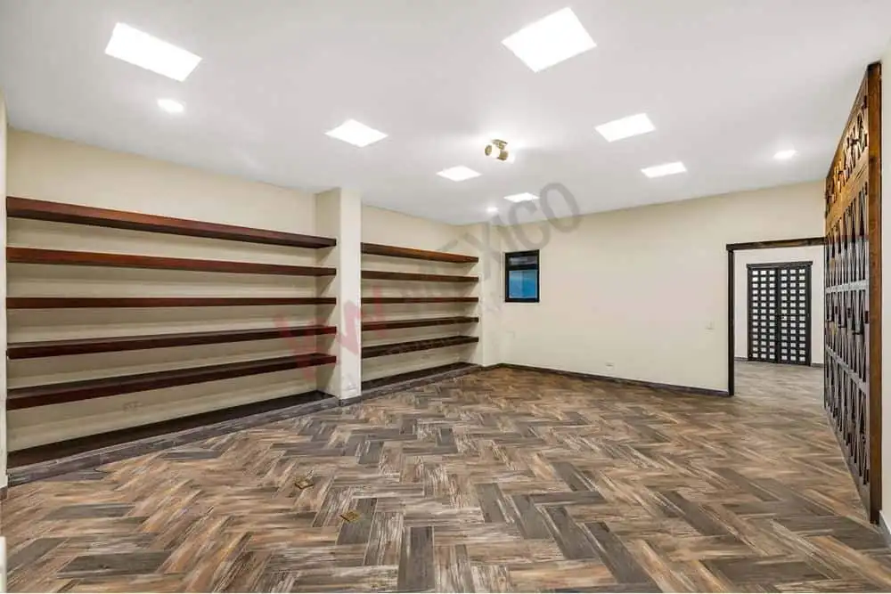 Empty retail store interior with wooden flooring and wall-mounted shelves for shop display.