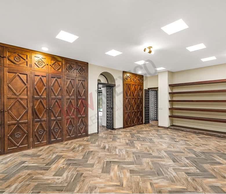Modern interior with wooden wall panels and shelving for storage and display.