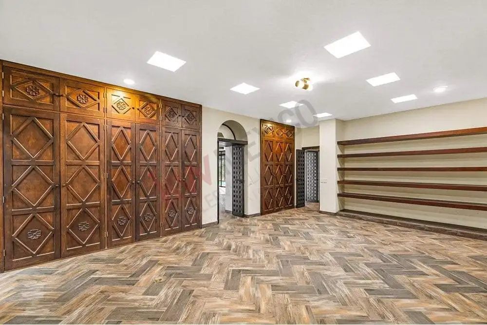 Modern interior with wooden wall panels and shelving for storage and display.