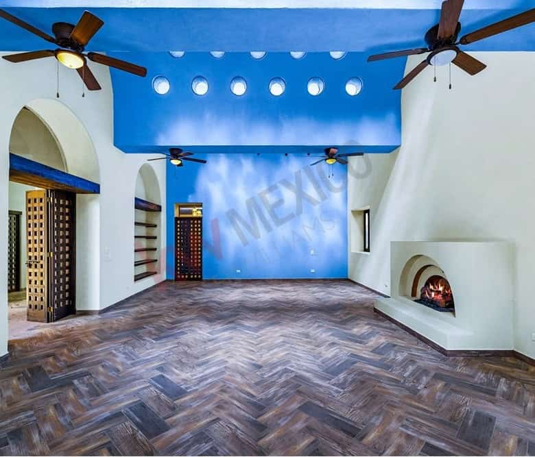 Modern living room featuring a vibrant blue ceiling, ceiling fans, and a cozy fireplace for comforta.