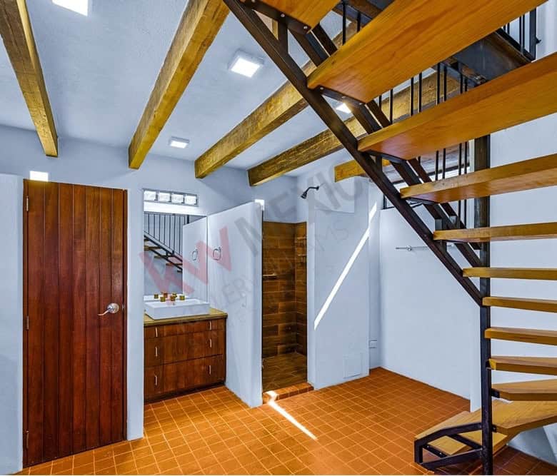 Interior view of a home with wooden staircase and ceiling beams.