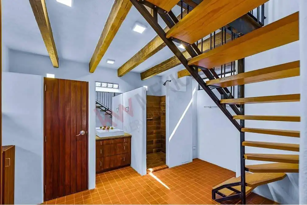 Interior view of a home with wooden staircase and ceiling beams.