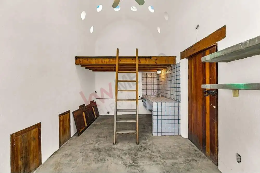 Cozy studio with wooden accents, loft area, and unique circular window design.