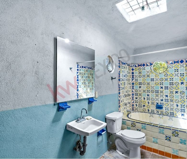 Bathroom with bathtub, sink, and toilet featuring vibrant patterned tiles.
