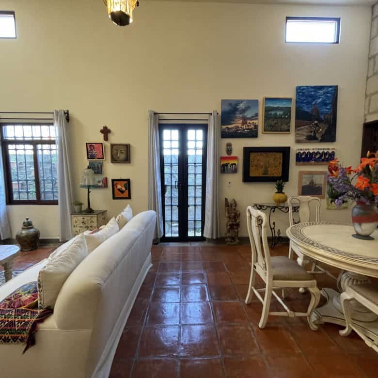 Interior of a cozy living room with artwork, furniture, and decorative items.