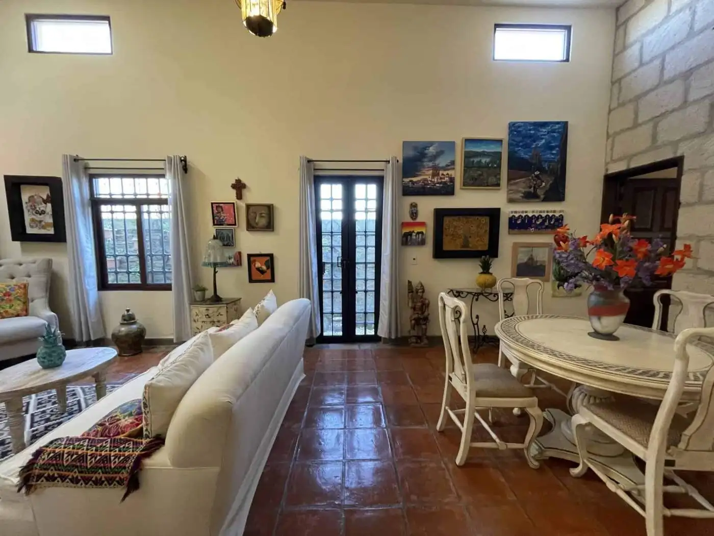 Interior of a cozy living room with artwork, furniture, and decorative items.