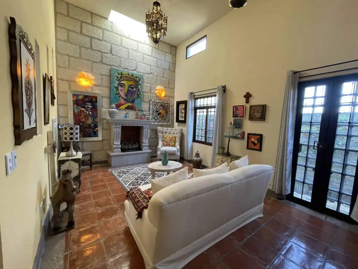 Bright living room with artwork, fireplace, and large glass doors for natural light.