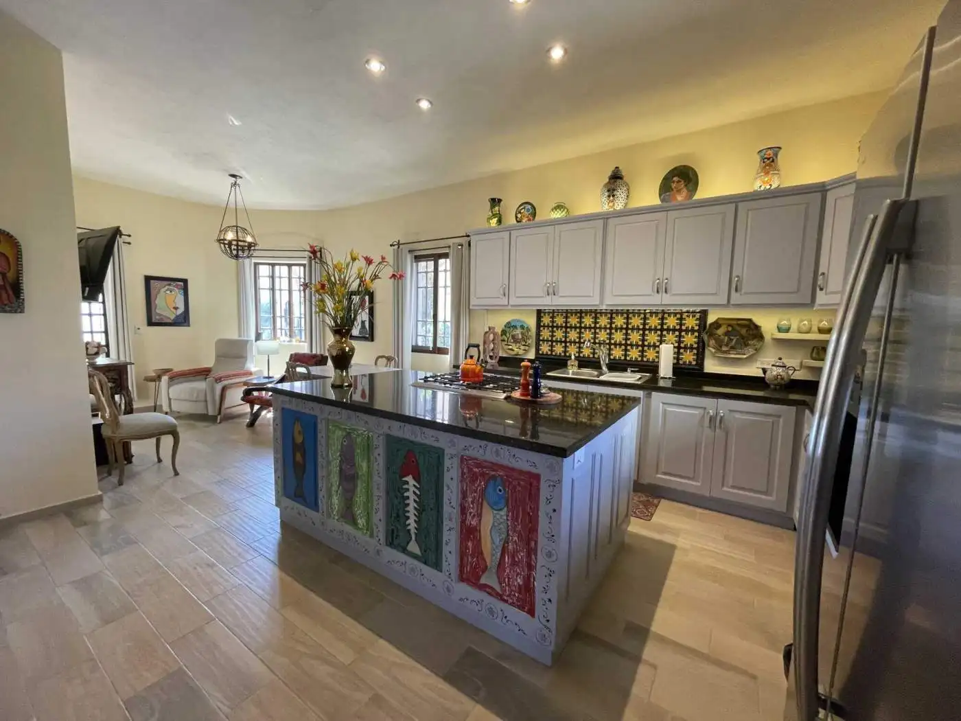 Bright kitchen featuring a vibrant, artistic island and stylish decor elements.