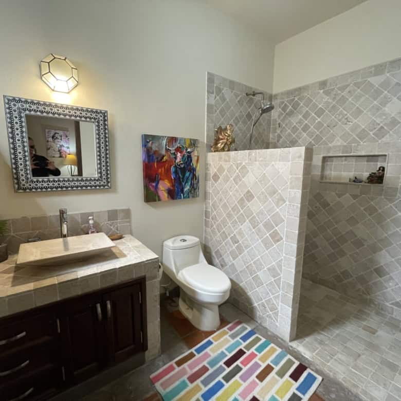 Modern bathroom with walk-in shower, toilet, and contemporary decor elements.