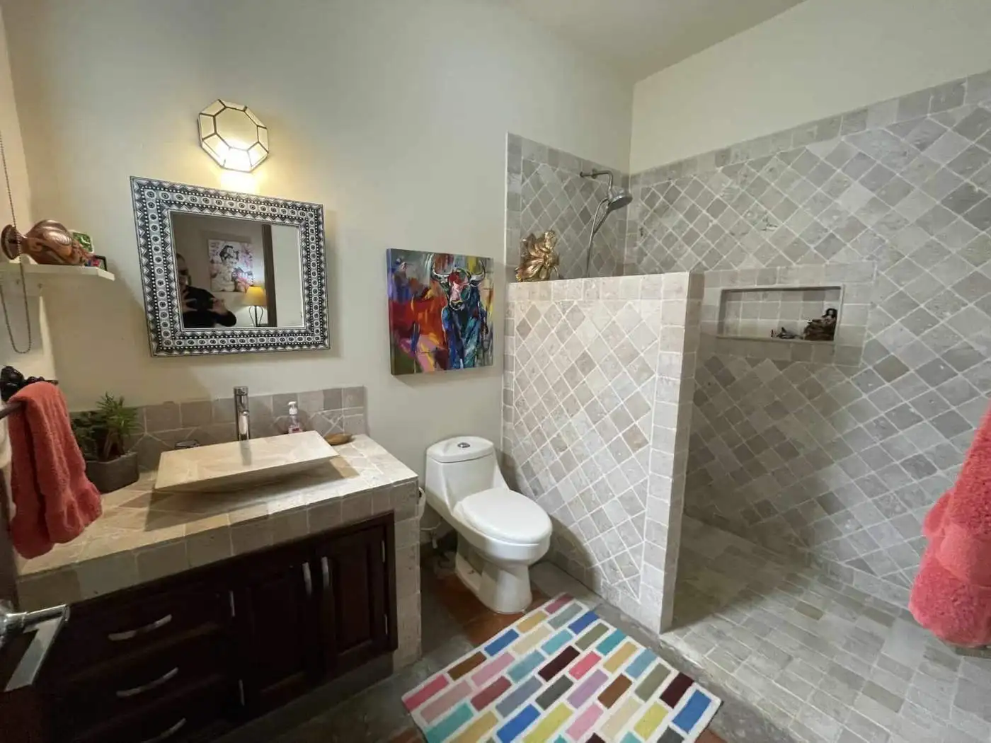 Modern bathroom with walk-in shower, toilet, and contemporary decor elements.