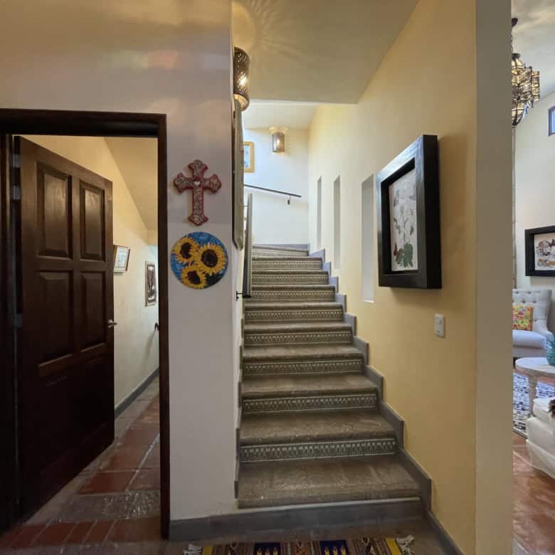 Bright hallway featuring a staircase and decorative wall art.
