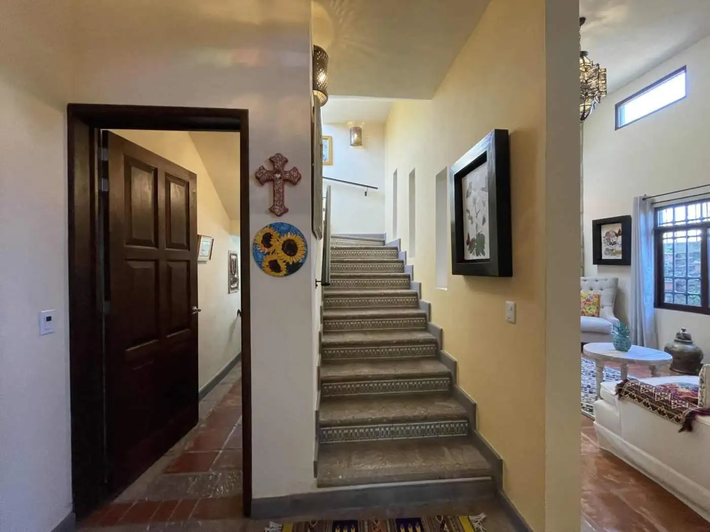 Bright hallway featuring a staircase and decorative wall art.