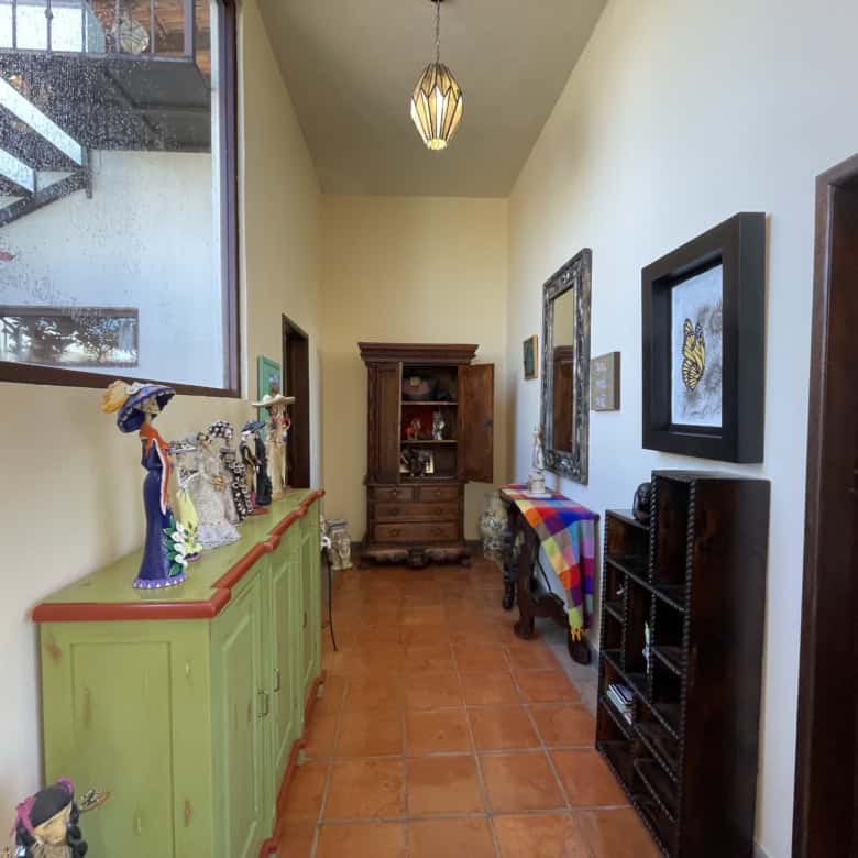Interior hallway with colorful art, furniture, and decor in a cozy home.