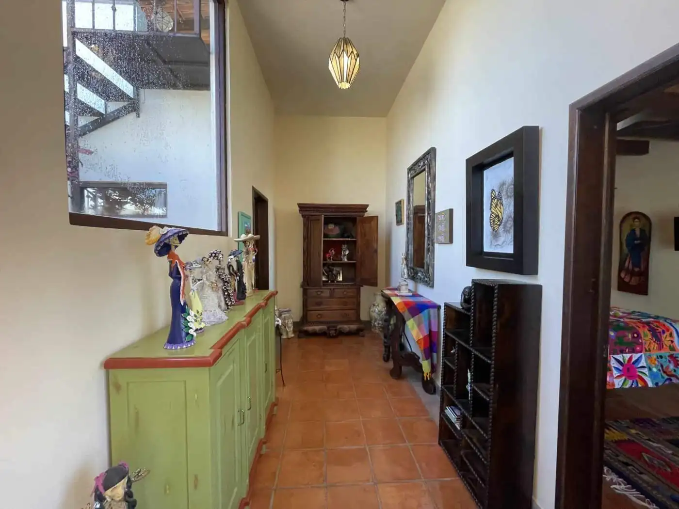 Interior hallway with colorful art, furniture, and decor in a cozy home.