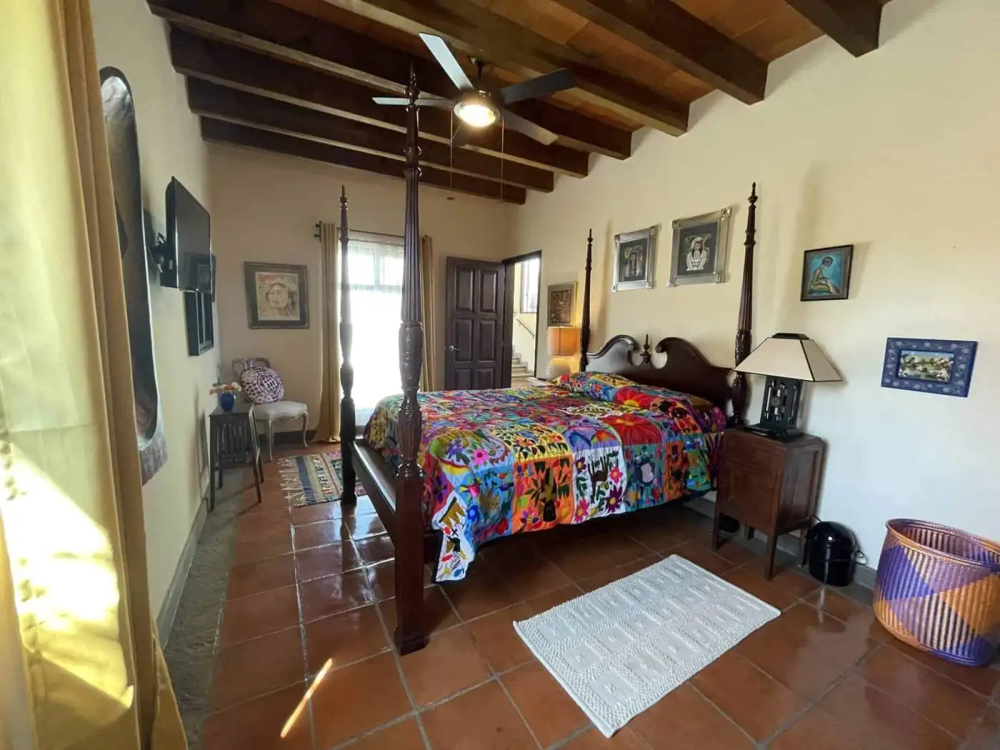 Cozy bedroom featuring wooden ceiling beams and colorful decor, perfect for a relaxing home environm.