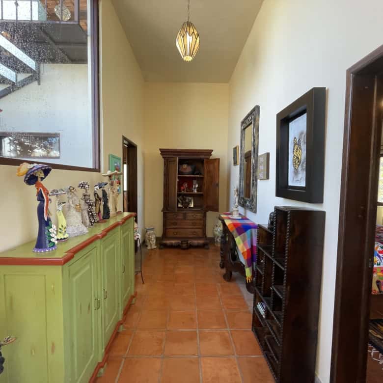Bright interior hallway with vibrant furniture and artwork, leading to a cozy bedroom. Perfect for s.