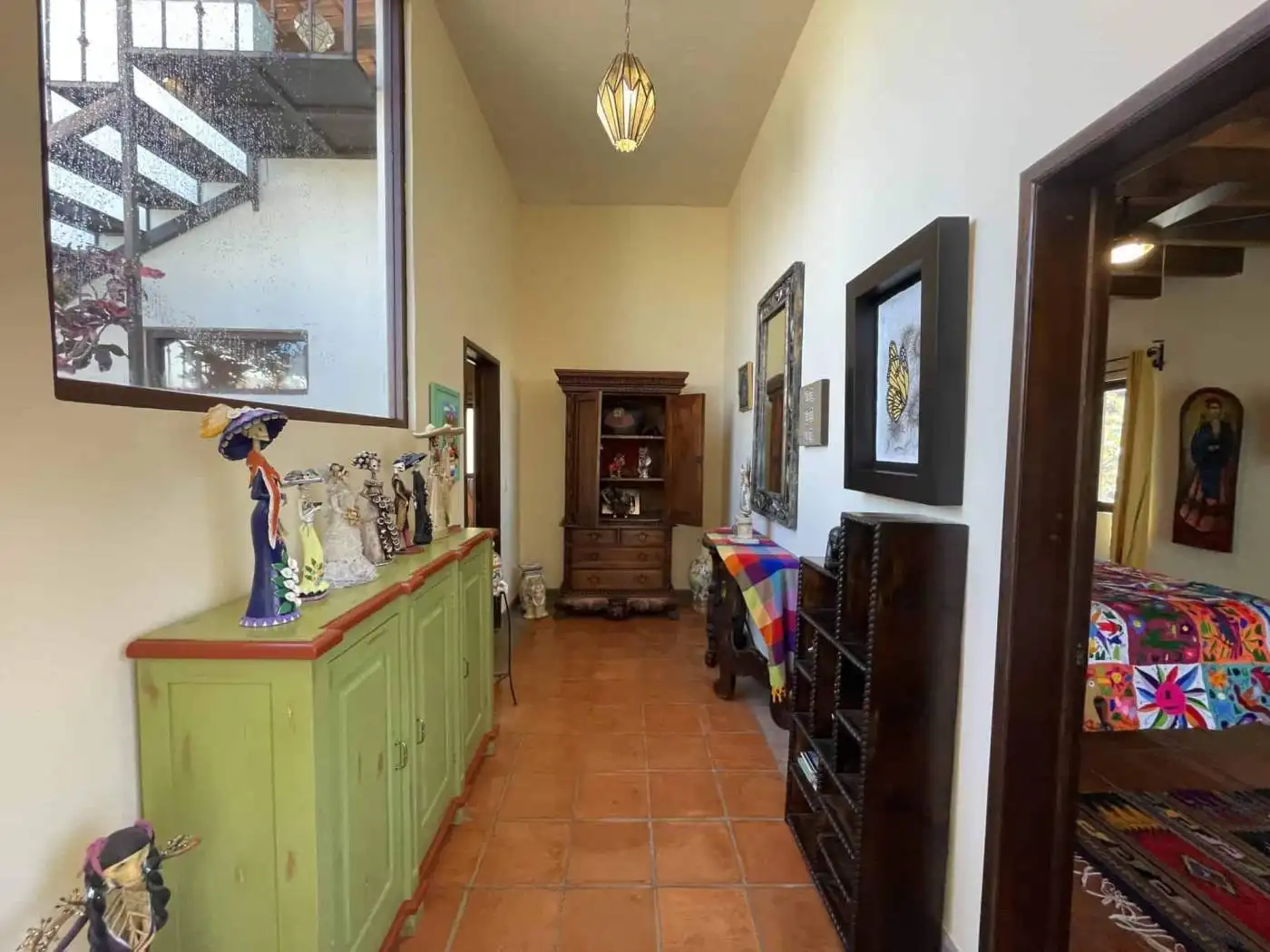 Bright interior hallway with vibrant furniture and artwork, leading to a cozy bedroom. Perfect for s.