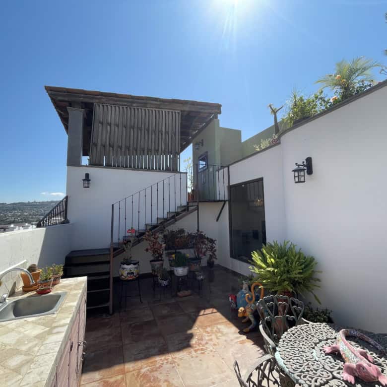 Rooftop terrace with outdoor furniture, potted plants, and city views in a contemporary property.