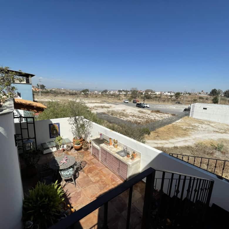 Outdoor terrace with seating area and cityscape view.