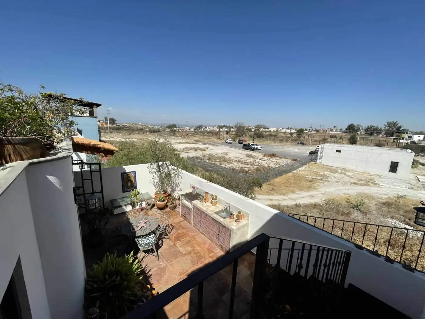 Outdoor terrace with seating area and cityscape view.