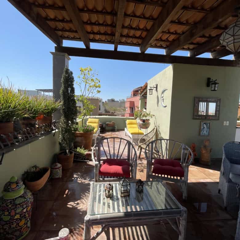 Balcony with city view, potted plants, and comfortable seating for relaxing outdoors.
