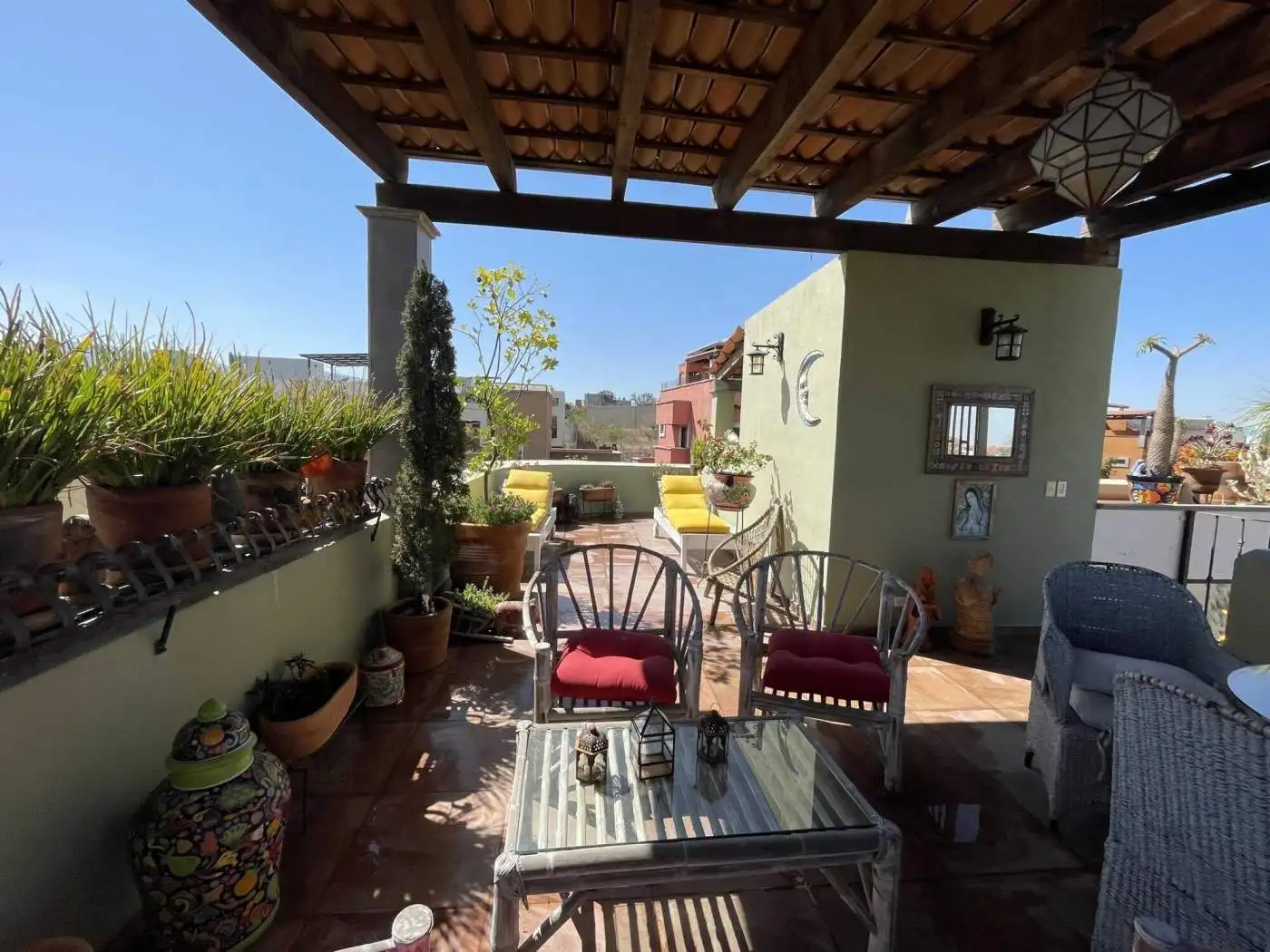 Balcony with city view, potted plants, and comfortable seating for relaxing outdoors.