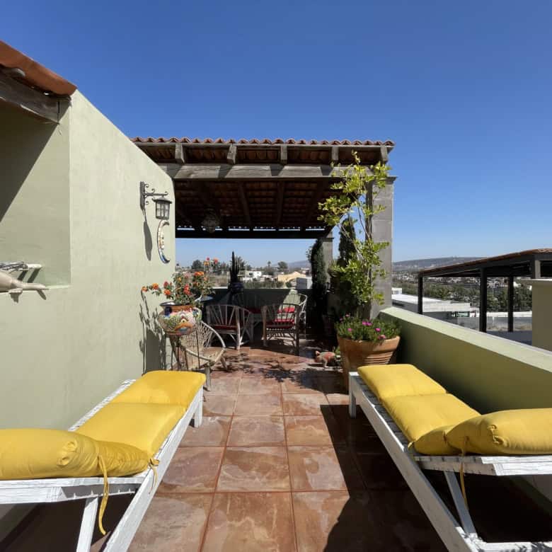 Rooftop terrace with seating and cityscape views, perfect for relaxing or entertaining guests. Brigh.