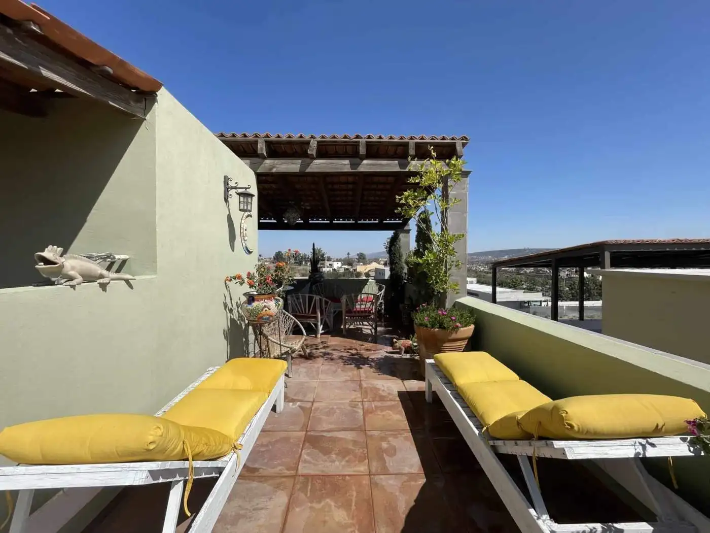 Rooftop terrace with seating and cityscape views, perfect for relaxing or entertaining guests. Brigh.