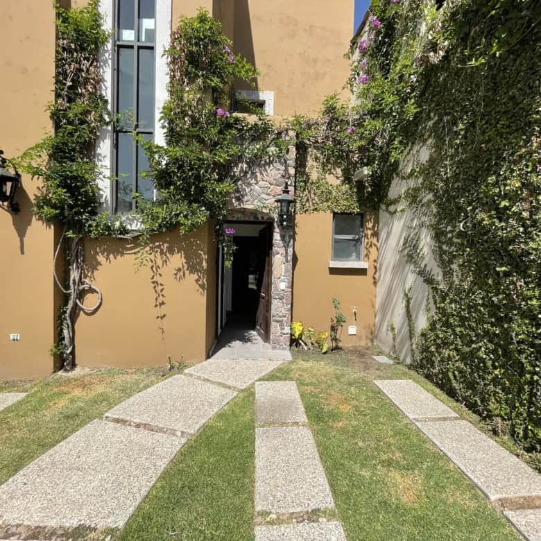 Beautiful courtyard with lush plants and stone pathway in a residential property.