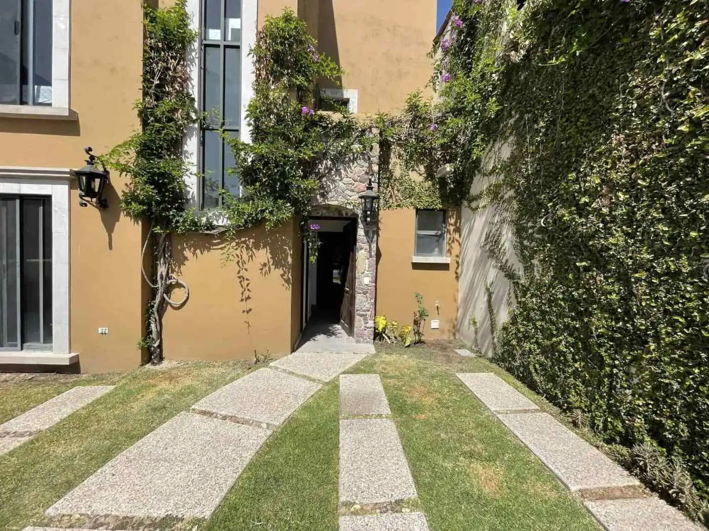 Beautiful courtyard with lush plants and stone pathway in a residential property.