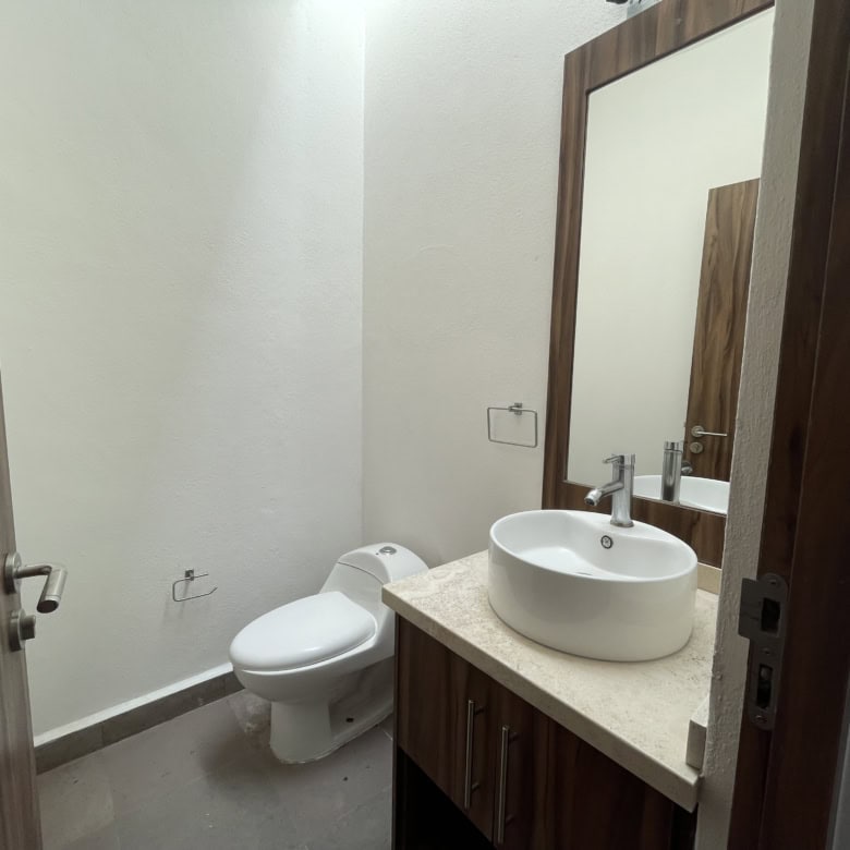 Bathroom with modern toilet and stylish vessel sink in a contemporary home.