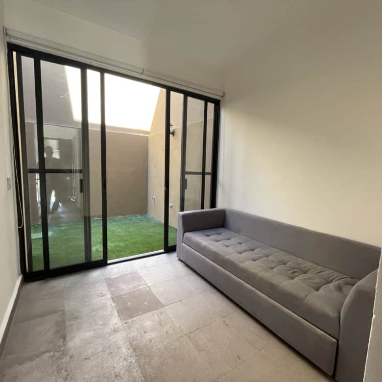 Modern living room with glass sliding doors leading to a small backyard.