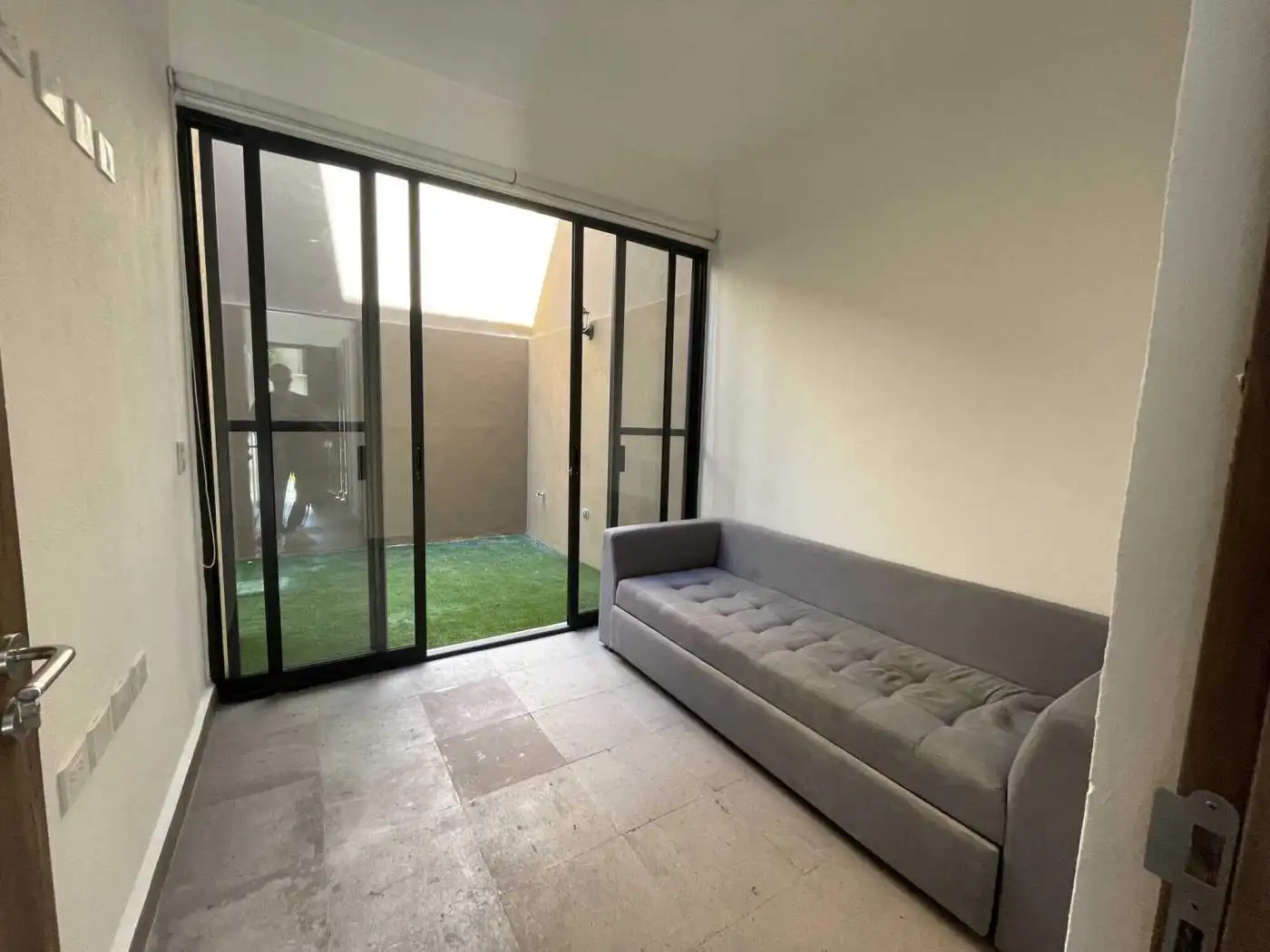 Modern living room with glass sliding doors leading to a small backyard.