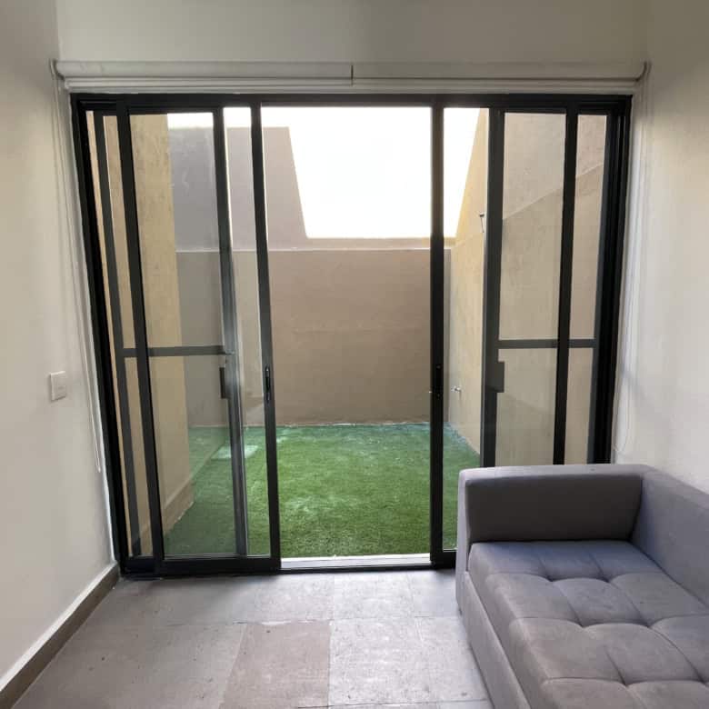 Modern apartment with sliding glass doors leading to a small outdoor patio.