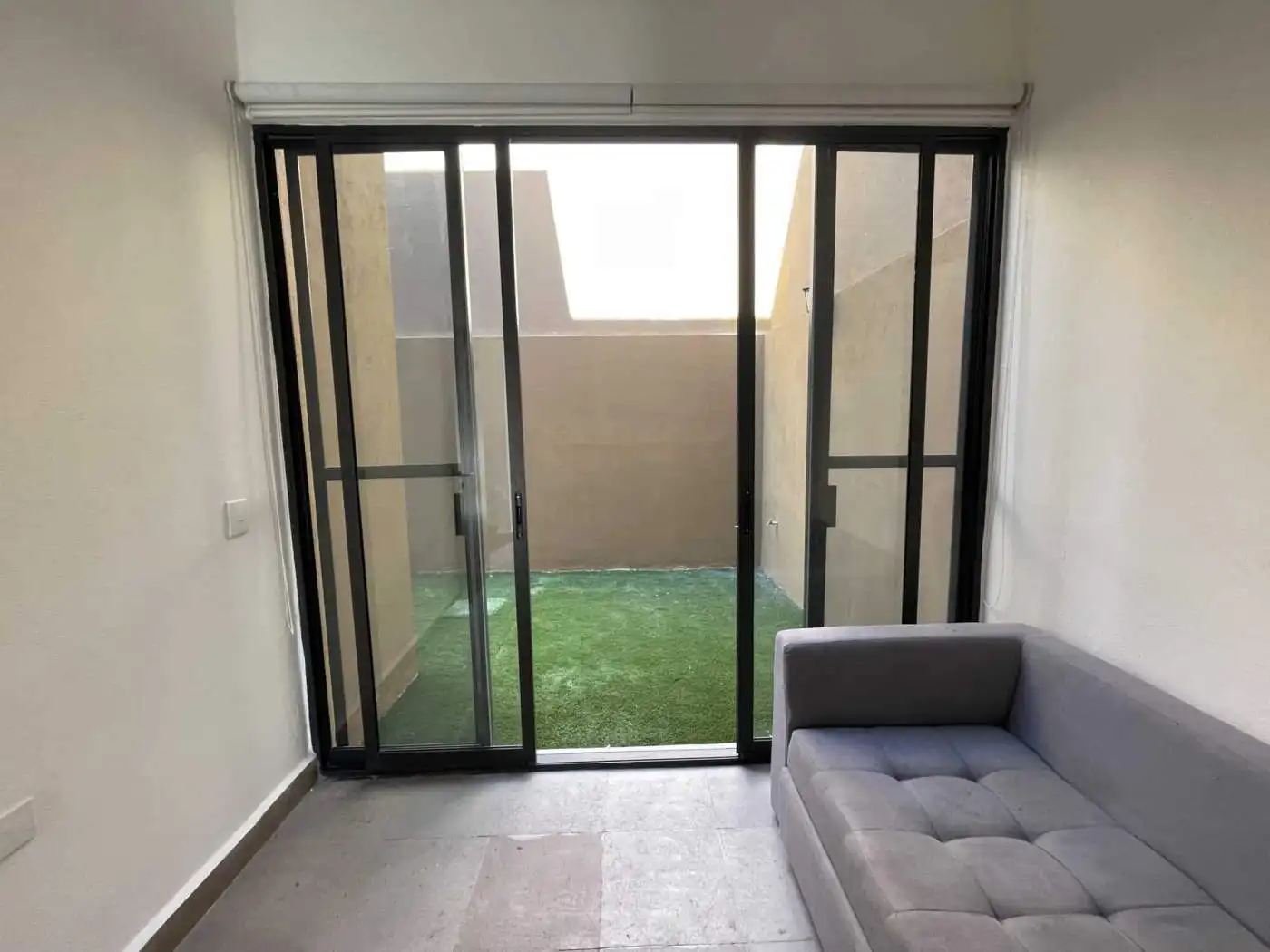 Modern apartment with sliding glass doors leading to a small outdoor patio.