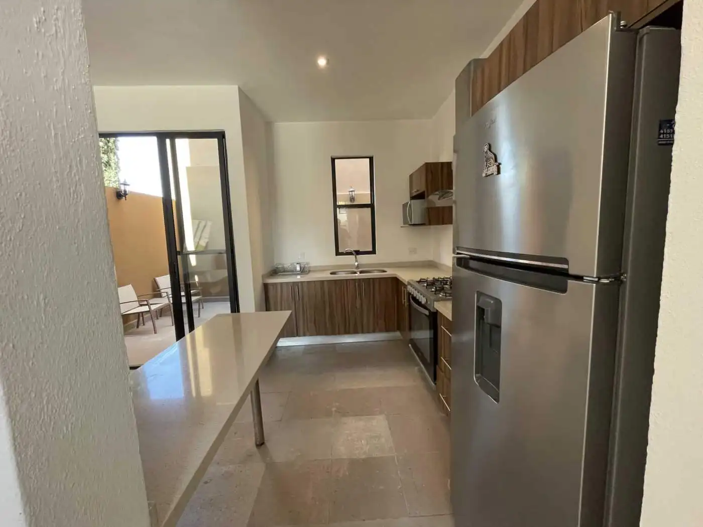 Modern kitchen with stainless steel appliances and wooden cabinets.