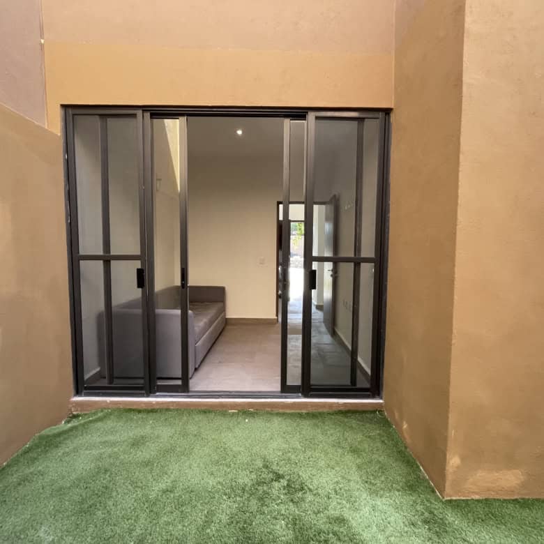 Balcony with glass sliding doors leading to a cozy indoor living area.
