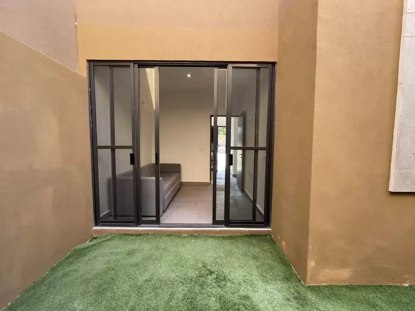 Balcony with glass sliding doors leading to a cozy indoor living area.