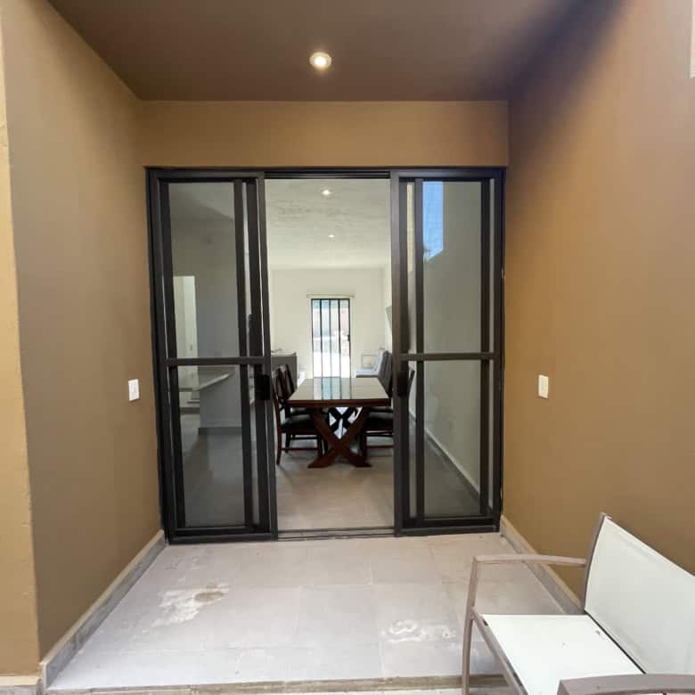 Modern room with glass sliding doors leading to dining space.