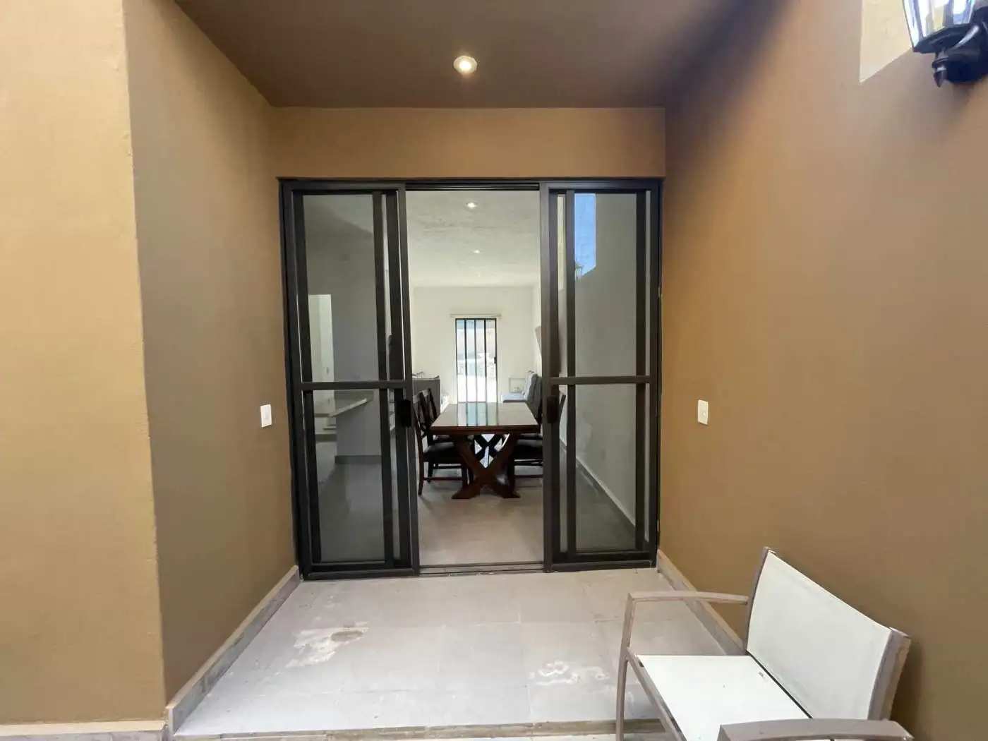 Modern room with glass sliding doors leading to dining space.