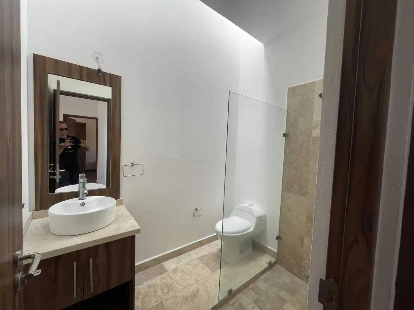 Modern bathroom with white sink, mirror, and toilet in a contemporary home.