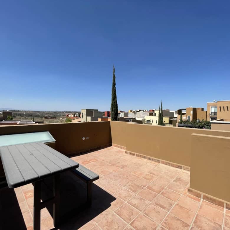 Rooftop terrace with cityscape views and outdoor furniture for relaxation.