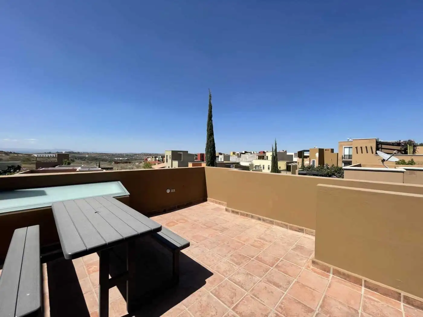 Rooftop terrace with cityscape views and outdoor furniture for relaxation.